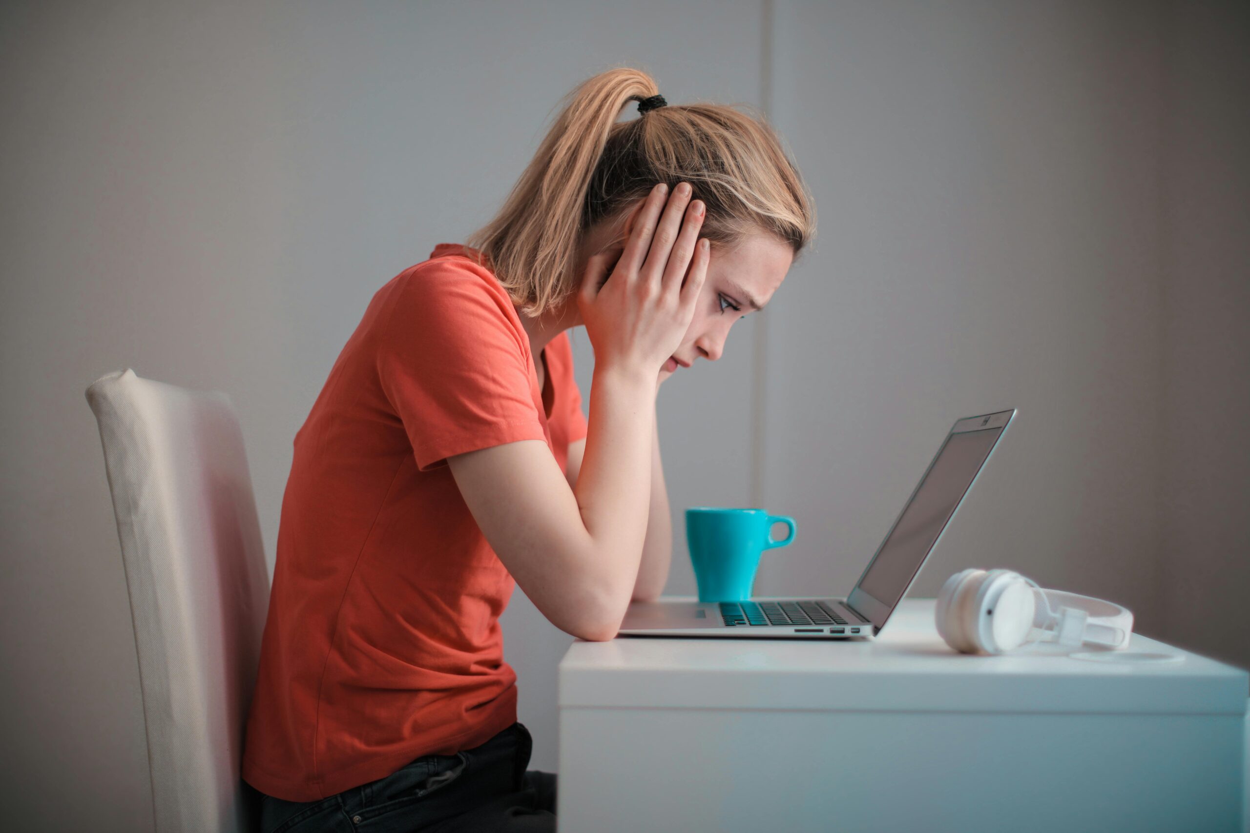 Woman with Head in Hands Facing Computer
